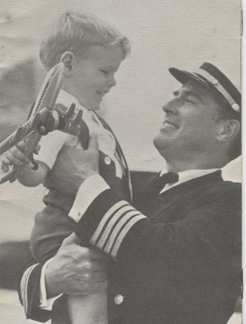 1970, November, A Pan Am pilot holds a young flyer in his arms.